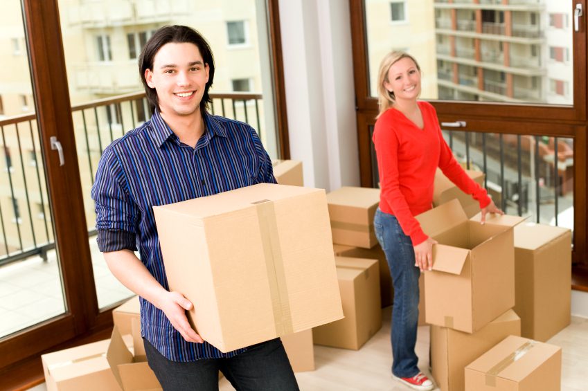 A man and woman moving boxes into their new home.